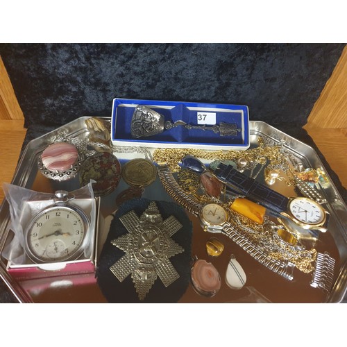 37 - Tray Of Costume With Pocket Watch, Military Cap Badge, Large Celtic Pendant , White Metal Spoon etc