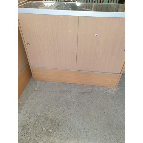 238 - A Large Shop Cabinet (122x97x45cm) With Glass Front Glass Shelves And Sliding Access Doors