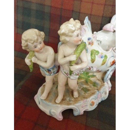 92 - A 19th century German Porcelain Sweet Meat Dish In Form Of 2 Cherubs Pulling a 2 Wheeled Cart All Ha... 