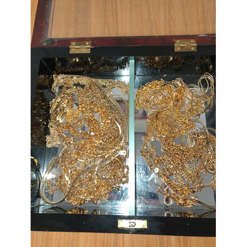 63 - A Mirrored Display Box containing yellow metal Jewellery