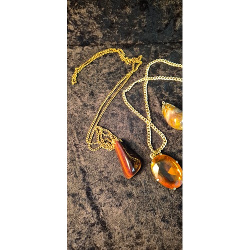 50H - A collection of four Agate pendants one hung on yellow metal chain together with orange pendant with... 