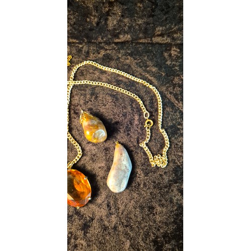 50H - A collection of four Agate pendants one hung on yellow metal chain together with orange pendant with... 