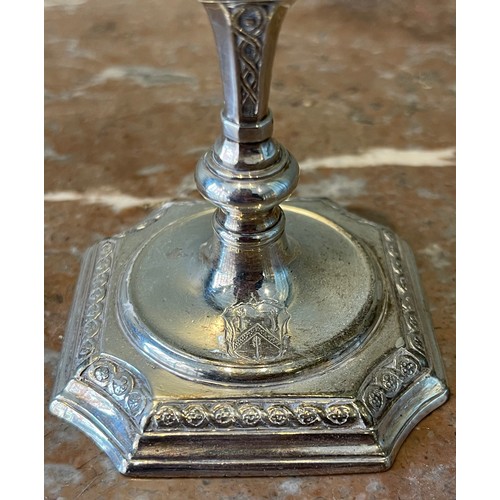 36 - A Pair of George I silver tapersticks. Each on a square base with in-curved angles, with baluster st... 