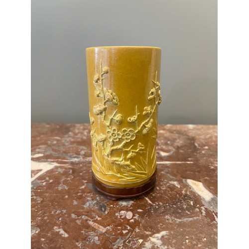 70 - A yellow cylindrical Chinese brush pot of bamboo form with bamboo and prunus blossom relief decorati... 