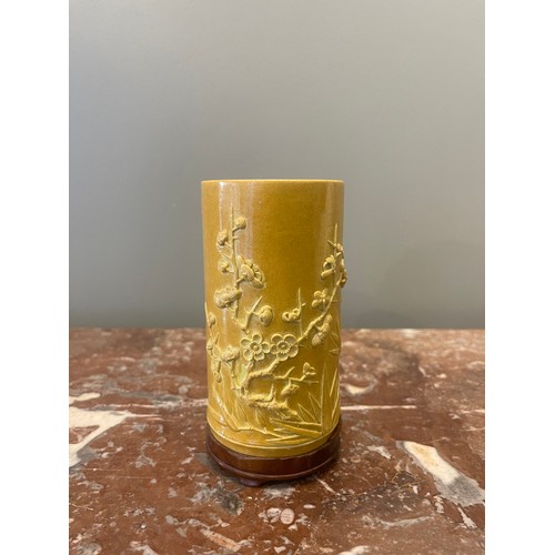 70 - A yellow cylindrical Chinese brush pot of bamboo form with bamboo and prunus blossom relief decorati... 