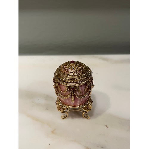 90 - A small jewelled hardstone egg on a stand in Russian taste. Banded pink hardstone. Gold setting with... 