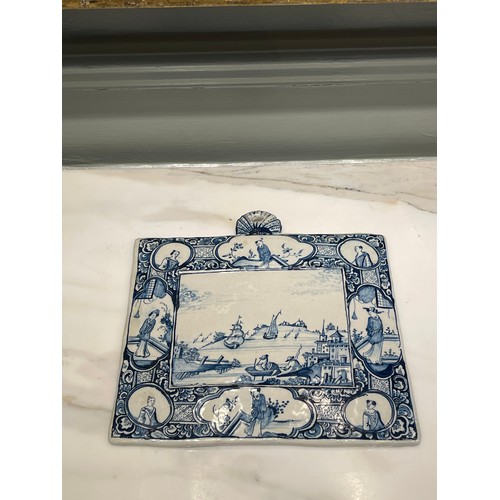 97 - A Dutch Delft blue and white rectangular genre plaque. Central marine landscape of port and figures ... 