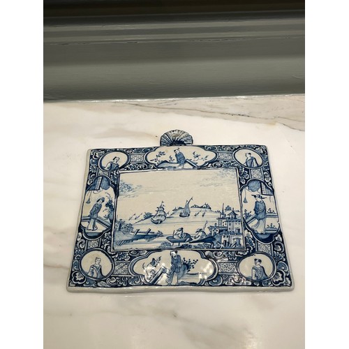 97 - A Dutch Delft blue and white rectangular genre plaque. Central marine landscape of port and figures ... 