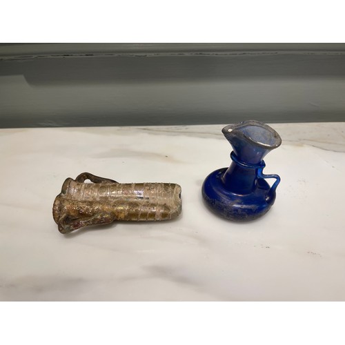 102 - A Roman blue glass vessel (a) and Roman glass miniature double-amphora (b).Condylis CollectionDimens... 