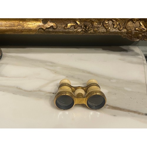 150 - Property of a GentlemanA pair of bone and brass opera glasses. 19th Century. In a leather case. The ... 