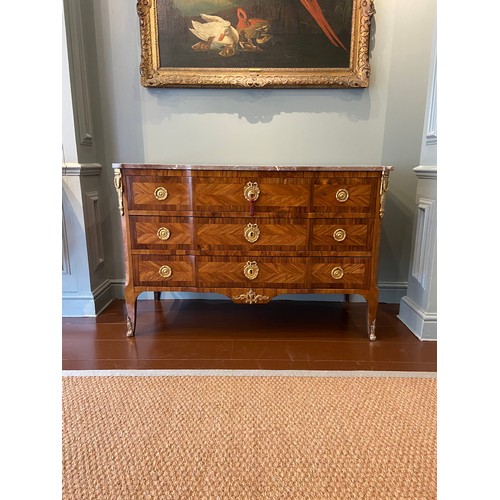 211 - A Louis XV ormolu-mounted kingwood and fruitwood commode with a rouge marble top and three long draw... 