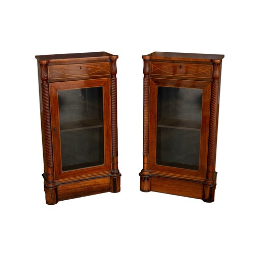 16 - RegencyA pair of mahogany glazed side cabinets, with twist scrolled columns capped with foliate carv... 