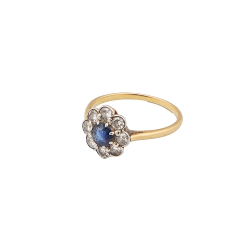 69 - Edwardian A circular cut sapphire cluster ring  Within a surround of eight round brilliant cut ... 