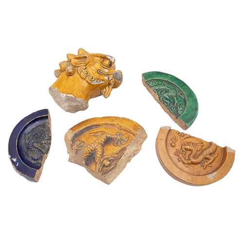 472 - Ming DynastyA yellow glazed fragment of a Buddhist lion roof tile figure and four glazed roundel fra... 