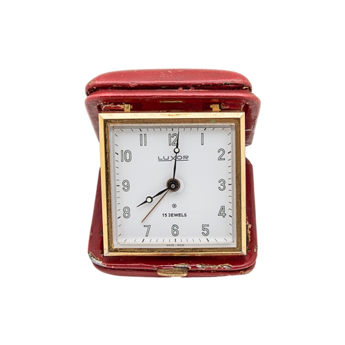 130 - A Luxor travelling clock covered in red leather, and a vintage leather cigar holderTo be sold withou... 