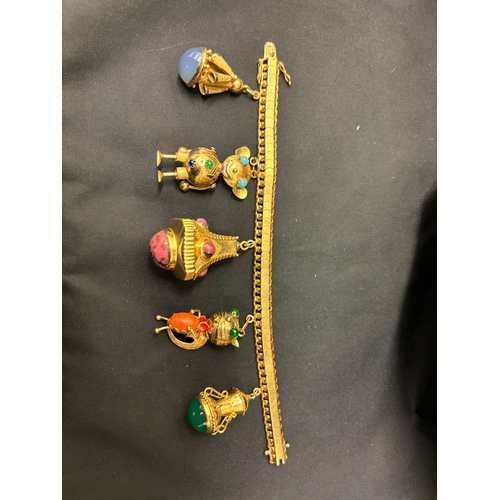 75 - An attractive 1950s gold charm bracelet with five large gem set charms To a flexible scaled curb lin... 