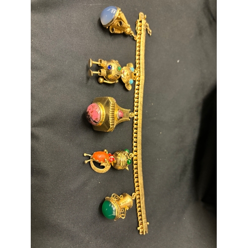 75 - An attractive 1950s gold charm bracelet with five large gem set charms To a flexible scaled curb lin... 