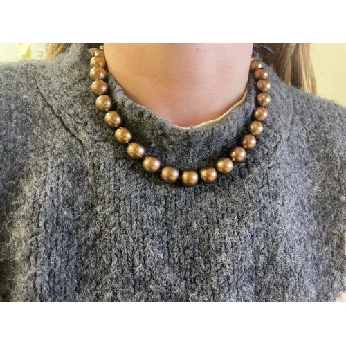 106 - A bronze Tahitian cultured pearl necklaceComprising 33 12-14mm cultured pearlsTo a yellow gold bolt ... 