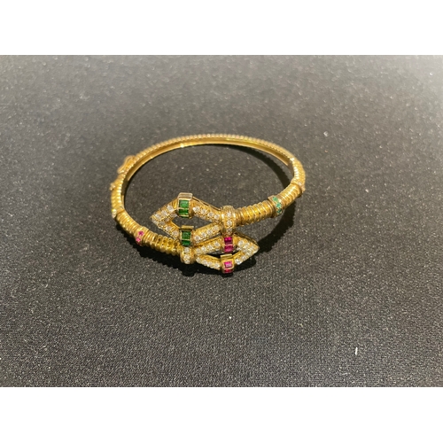 98 - Circa 1980A diamond, emerald, and ruby, yellow metal bangle of fluted designWeight:Approximatel... 