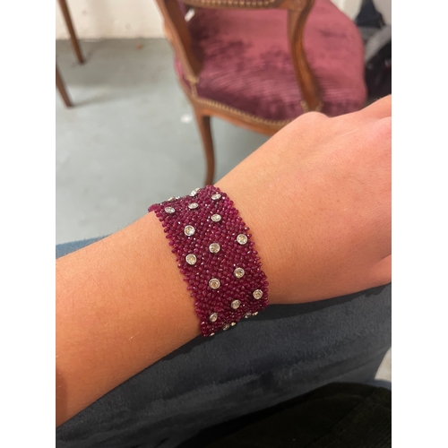 104 - A ruby and diamond braceletComposed of a wide mesh of faceted ruby beads applied with rose cut diamo... 