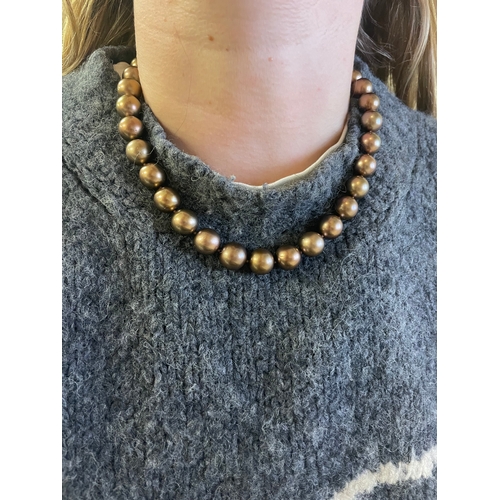 106 - A bronze Tahitian cultured pearl necklaceComprising 33 12-14mm cultured pearlsTo a yellow gold bolt ... 