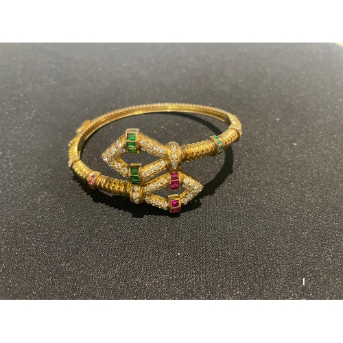 98 - Circa 1980A diamond, emerald, and ruby, yellow metal bangle of fluted designWeight:Approximatel... 