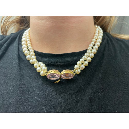 77 - A pink topaz and two row cultivated pearl necklaceThe graduated two row necklace set to the side wit... 