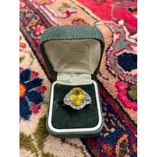 85 - A yellow sapphire and diamond cocktail dress ringThe oval shaped mixed cut yellow sapphire of good c... 