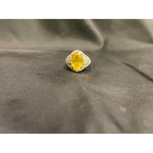 85 - A yellow sapphire and diamond cocktail dress ringThe oval shaped mixed cut yellow sapphire of good c... 