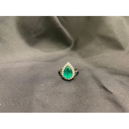 86 - A pear shaped emerald and diamond cluster ringThe pear shaped emerald of good colour within a surrou... 