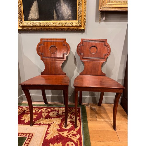 255A - Late 19th/ Early 20th centuryA pair of mahogany hall chairsWith carved detail to the backsDimensions... 