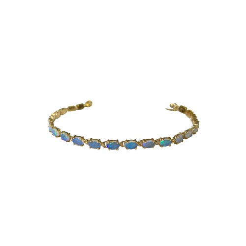 23 - A 14 carat yellow gold and black opal line braceletComprising 22 uniform sized opalsWeight:Approxima... 
