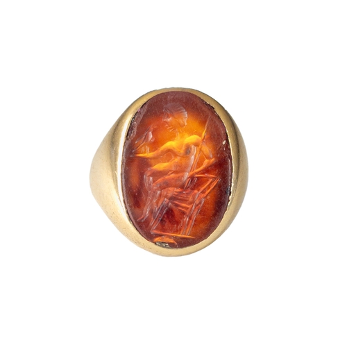 55 - A large Roman carnelian intaglio set in a heavy antique gold ringRepresenting a young man, possibly ... 
