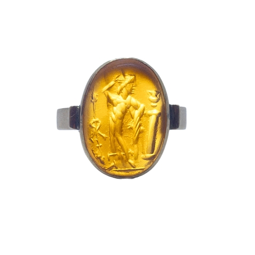 61 - A Roman pale carnelian intaglio of a male figure, possibly a solider? gazing down at a lidded vessel... 