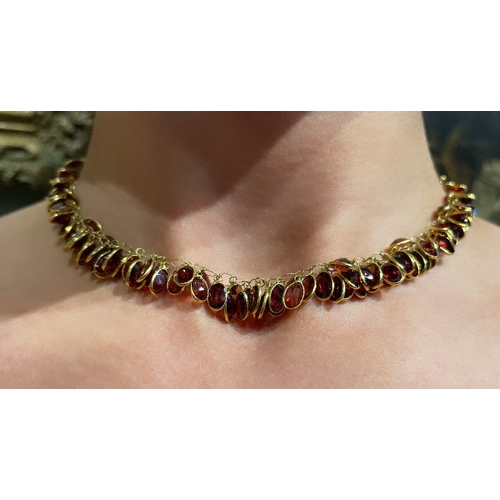 96 - EuropeanContemporaryA pretty garnet and 14 carat yellow gold fringe necklace set throughout with spe... 