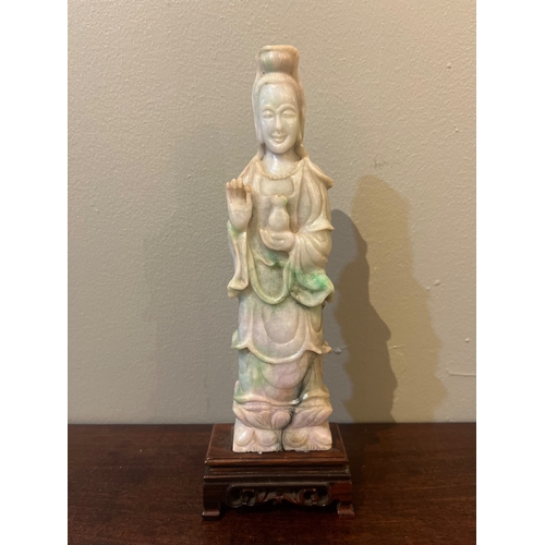 118 - ChineseCirca 1920A jadeite figure of Guan YinMounted on a carved hardwood baseDimensions: (Figu... 