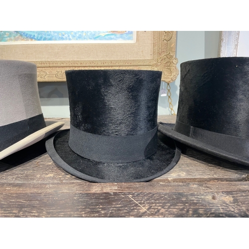 488 - 20th CenturyA group of three top hats[a] A Delicon black silk top hat[b] A Woodrow black silk top ha... 