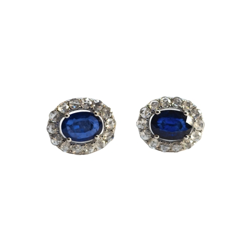 139 - BritishContemporaryA pretty pair of sapphire and diamond cluster earringsEach central oval-shaped sa... 