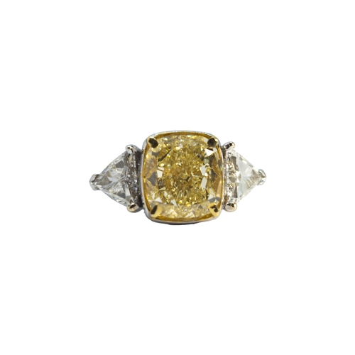 144 - EuropeanCirca 2000An impressive cushion-shaped yellow diamond and white diamond three-stone ringThe ... 