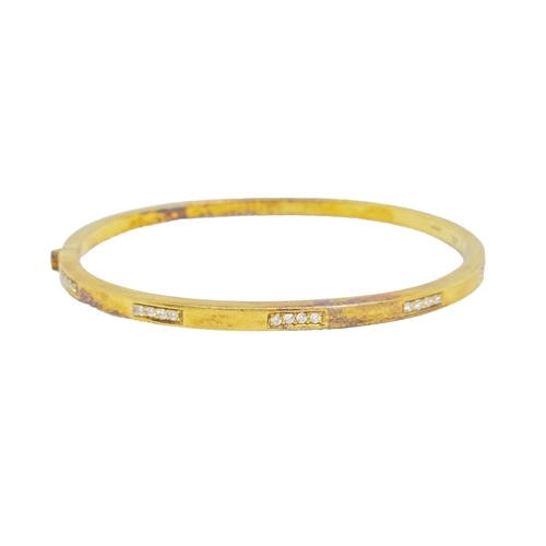 163 - BritishCirca 1980A diamond and 18 carat yellow gold bangleThe plain heavy yellow gold bangle set to ... 