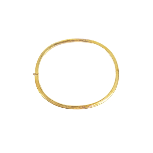 163 - BritishCirca 1980A diamond and 18 carat yellow gold bangleThe plain heavy yellow gold bangle set to ... 