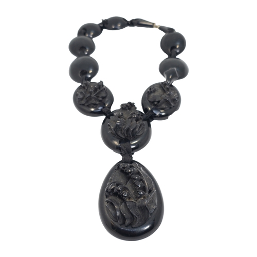 669 - British19th CenturyA Whitby jet necklaceThe front sections carved with floral motifsWeight: Approx. ... 