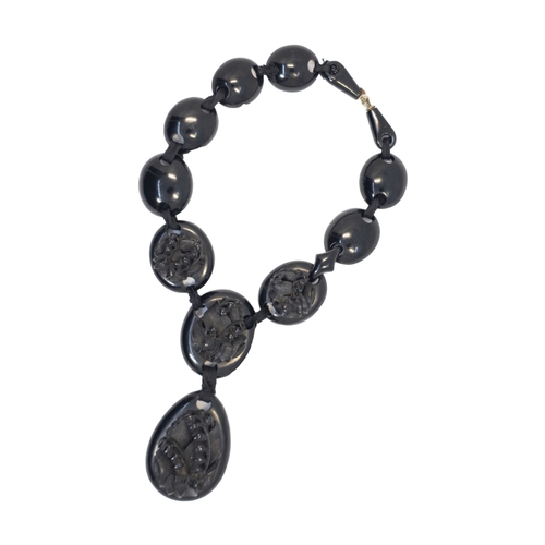 669 - British19th CenturyA Whitby jet necklaceThe front sections carved with floral motifsWeight: Approx. ... 