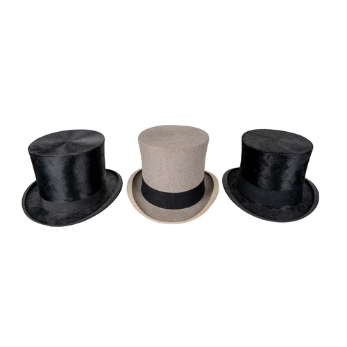 658 - 20th CenturyA group of three top hats[a] A Delicon black silk top hat, Circumference 57 cm.[b] A Woo... 