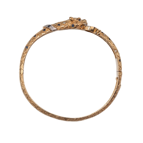 17 - ContinentalCirca 1980A 9 carat yellow gold, diamond and sapphire set leopard torc bangleThe head and... 