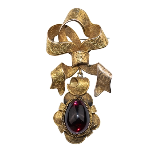 44 - VictorianCirca 1860A cabochon garnet bow broochThe open gold bow top engraved throughout the ribbon,... 