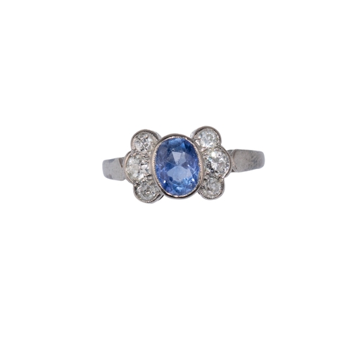 89 - BritishCirca 1920A sapphire and diamond dress ringThe central oval pale blue sapphire collett set wi... 