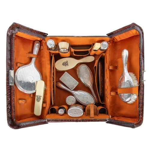 660A - 20th CenturyA crocodile leather vanity travel case with silver engraved and cut rock crystal persona... 