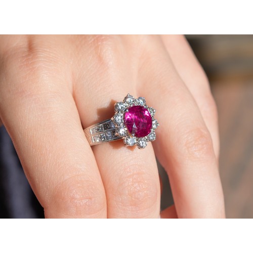 76 - ContinentalCirca 1980A fine ruby and diamond cluster ringThe central cushion shaped mixed cut ruby o... 