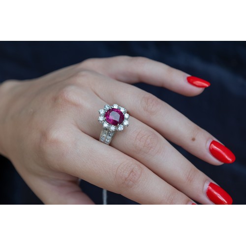 76 - ContinentalCirca 1980A fine ruby and diamond cluster ringThe central cushion shaped mixed cut ruby o... 